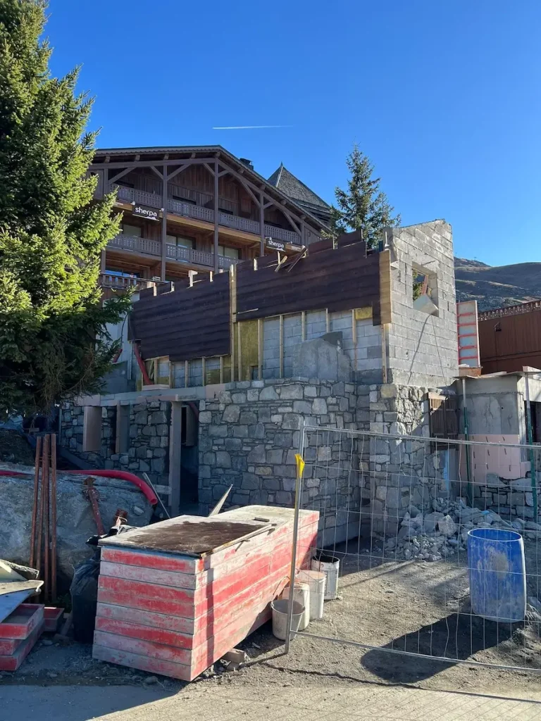 Chalet renovation in progress with stonework and timber cladding visible