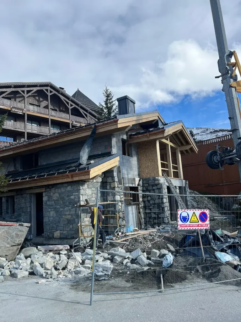 Chalet roof and stone chimney during exterior renovation work