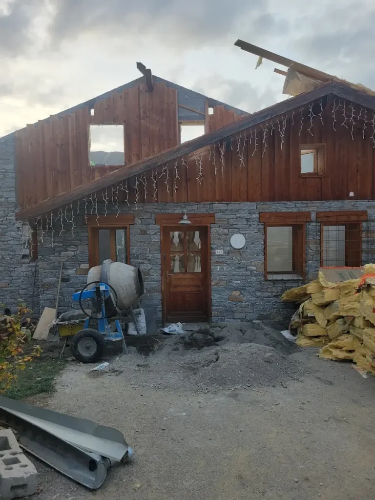 Chalet exterior with construction equipment during renovation