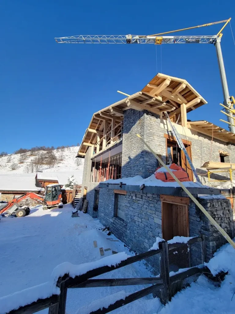 Chalet exterior renovation with roof works in winter