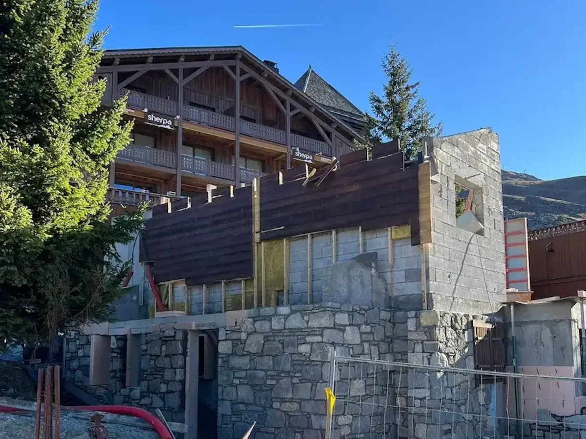 Chalet renovation in progress with stonework and timber cladding visible