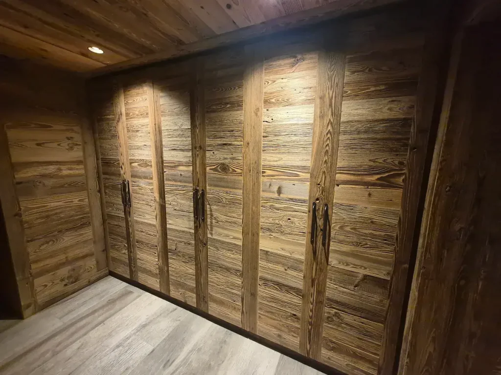 Fitted timber wardrobes built beneath a sloping chalet ceiling